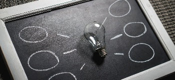 Image of chalkboard with a single light bulb