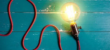 Image of lit up Edison style light bulb with cable.